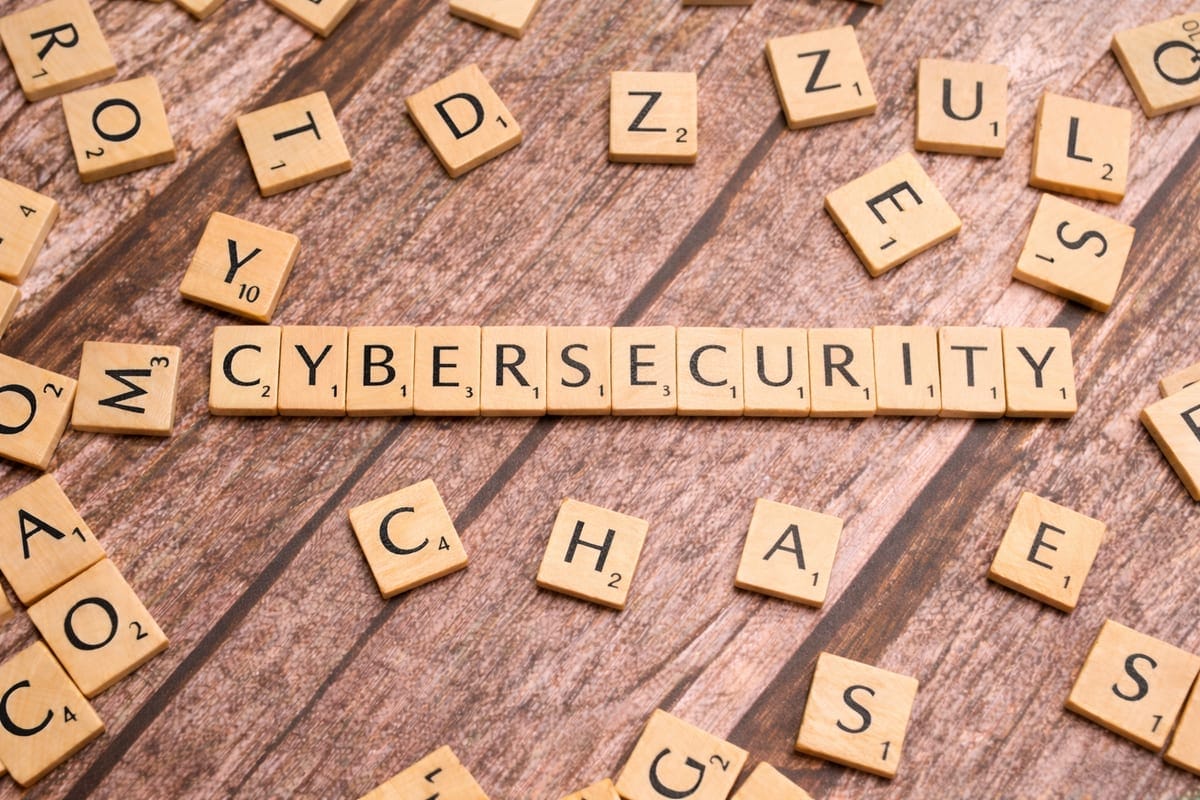 Scrabble tiles spelling CYBERSECURITY on a wooden surface. Photo by Markus Winkler on Unsplash.