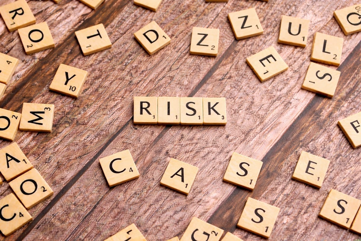 Scrabble tiles spelling RISK on a wooden surface. Photo by Markus Winkler on Unsplash.